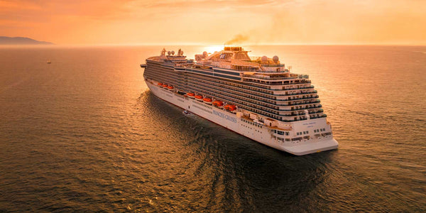 Cruise ship on the open ocean heading toward sunset